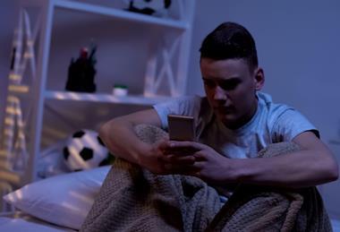 Anxious teenage boy with phone