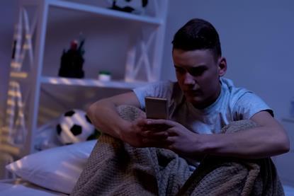 Anxious teenage boy with phone